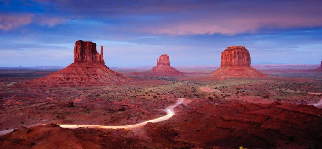 Auta projíždějící Monument Valley